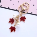 Detail of gold maple leaf keychain with red enamel charms and white faux pearls - Single OPP Bag Packaging / Burgundy