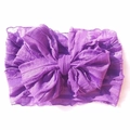 Detail of purple infant headband featuring a large bow and soft pleated texture fabric - Dark Purple