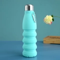 Dettaglio borraccia pieghevole in silicone blu cielo con moschettone su superficie blu - Blu