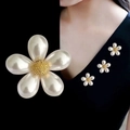 Detail of elegant pearl flower brooch with gold center on black and worn on lapel - Five Petal Pearl Flower