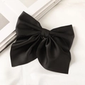 Close-up of a large black satin bow hair clip featuring a layered design and smooth texture - Black