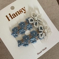 Detailed view of floral embroidery and pearl flower design on brown hair clips - Blue