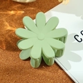 Matte hellgrüne Gänseblümchen-Haarklammer auf minimalistischem Kork- und Buchhintergrund - 4.8cm / Blassgrün