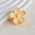 Detail of matte yellow flower hair claw clip with a five-petal design on white background - Apricot