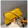 Close-up of a yellow crocodile-embossed leather handbag with gold metal hardware - Yellow