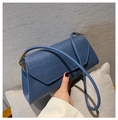 Detailed shot of blue crocodile pattern shoulder bag with a stylish triangular flap design - Blue