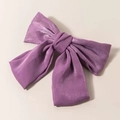 Dettaglio di un fiocco per capelli in raso viola con consistenza setosa e nastri eleganti - Fermaglio a Molla Viola