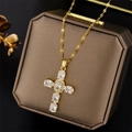 Gouden kruisketting met zirkonia stenen gepresenteerd op een bruin sieradendoosje - Wit