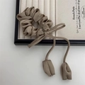 Elegant beige satin scrunchie with long bow and fabric charms on a wooden tray - Khaki