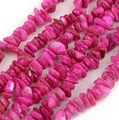 Makroaufnahme von unregelmäßigen Naturschalenperlen in Soft-Rosa für DIY-Schmuckherstellung - Rosenrote Muschelsplitter