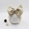 Detail of beige faux cashmere baby turban hat with a large bow on a mannequin - Off-white
