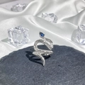 Macro shot of silver snake ring with blue pear gemstone and crystals on dark stone - Style 7 Adjustable Ring