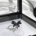Detailed close-up of a black butterfly ring with pink heart gemstone in a gift box - Black Butterfly Pink Heart Gem Style (10)