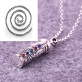 Detailed macro view of an engraved silver Buddhist pendant with colorful gemstone inlays - Pendant with Pearl Necklace