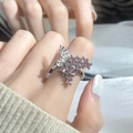 Macro detail of a silver butterfly ring with pink zircon stones worn on finger - Silver Pink Gemstone Butterfly