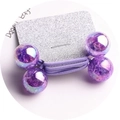 Detailed macro view of two purple iridescent beaded hair ties on a glitter card display - Purple