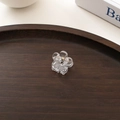 Nahaufnahme der mini transparenten Blumen-Haarklammer auf einem Holztablett - Transparent