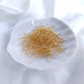 Macro shot of gold-plated flat head pins for DIY jewelry making in a shell dish - 0.5x26mm (100 Pcs) / 18K Gold