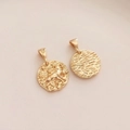 Dettaglio del ciondolo zodiacale placcato oro 14K con rilievo animale e trama a onde - Toro