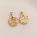 Macro view of 14K gold plated Libra zodiac pendant with textured finish and star pattern - Libra