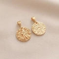 Macro detail of 14K gold-plated Aquarius zodiac charm showing embossed design and ripple texture - Aquarius