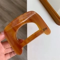 Vista dettagliata della molletta per capelli tartarugata ambra con stampa lettere Do - Caramello D Molletta