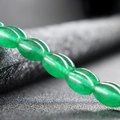 Strand of green oval jade beads with a polished finish for DIY jewelry making - Malay Jade