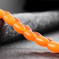 Polished 8x12mm oval amber agate beads in a vibrant orange finish for DIY jewelry - Orange