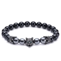 Macro shot of a black agate beaded bracelet with a silver wolf head and crown charms - 8mm Natural Black Agate