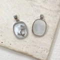 Detailed view of 14k gold-filled mother-of-pearl rose pendants on a stone background - White Gold
