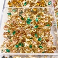 Macro shot of gold cherry pendants with champagne and green zircons in a storage box - Champagne