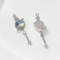 Détail macro du pendentif planète en or 14k serti de zircon et breloque étoile sur blanc - Pièce Unique / Or Blanc