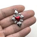 Pendente stella gotica con cuore rosso mostrato su una mano con sfondo bianco neutro - Cuore Rosso Croce Raggi di Sole