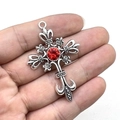 Pendentif croix punk gothique argenté avec une pierre rouge centrale en main - Ton Argent Pierre Rouge
