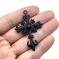 Pendentif croix gothique punk avec gemme noire présenté dans la paume pour la taille - Base Noire Avec Pierre Noire