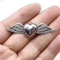 Vintage silver gothic heart wing pendant displayed on hand for scale and detail - Antique Silver Heart Wings