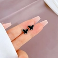 Detalle de pendientes de mariposa plateados con incrustación negra sobre seda suave - Mariposa de Acero (Q504) / Color Acero