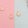 Detail eines goldenen Kronenanhängers mit weißen Kunstperlen für DIY-Ohrringe - Rosa