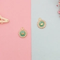 Makro-Detail von rundem mintgrünem Emaille-Anhänger mit Goldkrone und Perlenrand - Blau