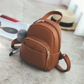 Detalle de la textura de cuero marrón de la mochila con pompón de piel gris suave - Con bola de pelo / Marrón