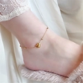 Minimalist 18K gold heart anklet with small beads shown on a woman wearing fuzzy slippers - Heart Anklet (11)
