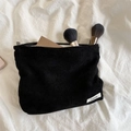 Detail of a black corduroy makeup bag showing large capacity storage with cosmetics - Black