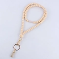 Detail of wooden bead lanyard with heart carving, gold lobster clasp and beige leather tassel - Heart