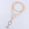 Detail of wooden bead lanyard with engraved star bead, lobster clasp, and beige tassel - Star