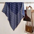 Detail of navy blue printed square scarf hanging next to a white blazer and tan leather bag - 68*68cm / Blue