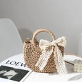 Khaki woven straw bag featuring elegant white lace bow detail for beach vacation style - Coffee