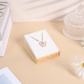 Detail of a butterfly pendant with pink stone on a white velvet jewelry display stand - 7*8 Pendant Rack / Beige Velvet