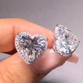 Macro shot of silver heart halo stud earrings with sparkling cubic zirconia stones - White Gold