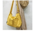Detalle del bolso bandolera de lona amarilla con bolsillo frontal y correa ajustable - Amarillo