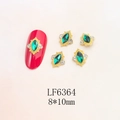 Macro detail of 8x10mm green marquise nail gems with gold retro frames and micro-diamonds - Gold Base Emerald Marquise (6364)